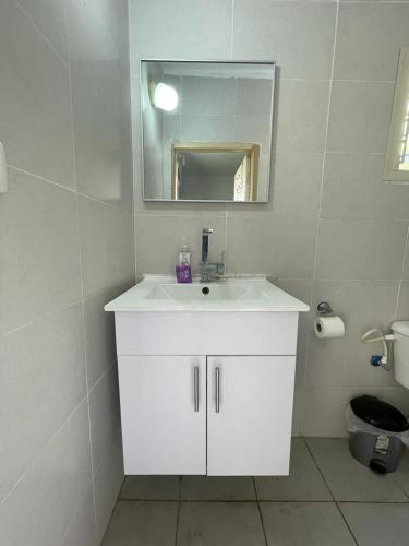 a white bathroom with a sink and a mirror at פרטיות וחוויה אצל יעקב וירדנה Privacy and an experience at Jacob and Yardena in El ‘Affūle