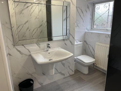 a bathroom with a sink and a toilet and a mirror at Beautiful 3 Bed House with Hot Tub in Blaydon Burn 
