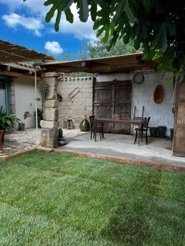 un patio al aire libre con mesa y sillas en Graziosa stanza campidanese Su terzu, en Oristano