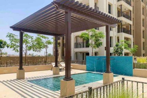 a pergola over a swimming pool in front of a building at Spacious 2 bedroom in Madinat Jumeirah Living in Dubai