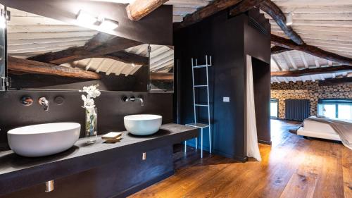 bagno con due lavandini in una camera con soffitti in legno di AQUADIVINA 16, Emma Villas a Palaia