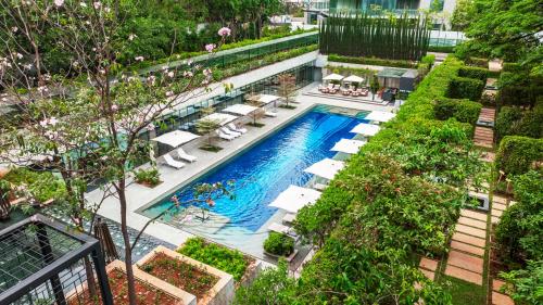 uma vista sobre uma piscina com espreguiçadeiras e árvores em Four Seasons Hotel Bengaluru at Embassy ONE em Bangalore
