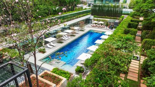 - une vue sur la piscine bordée de chaises longues et d'arbres dans l'établissement Four Seasons Hotel Bengaluru at Embassy ONE, à Bangalore