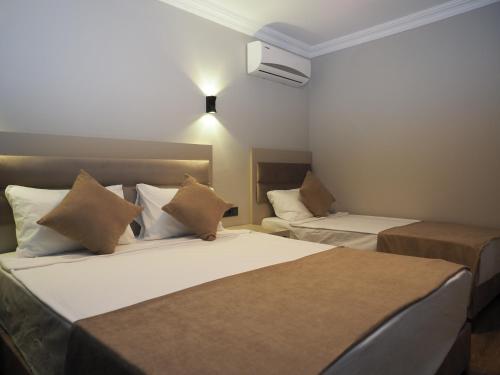 una camera d'albergo con due letti e un calorifero di ZENİA OTEL a Antalya (Adalia)