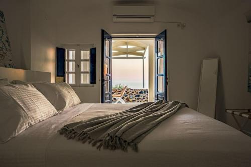 a bedroom with a bed with a view of the ocean at Sylvia's Villa in Imerovigli