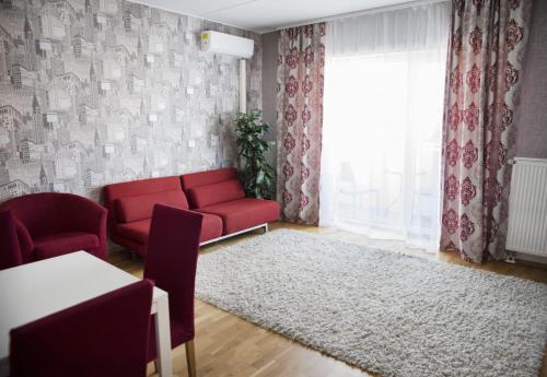 een woonkamer met een rode bank en een tapijt bij Aleksandria Apartment in Pärnu