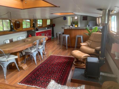 une cuisine et un salon avec une table et des chaises dans l'établissement Péniche Odilia, à Avignon