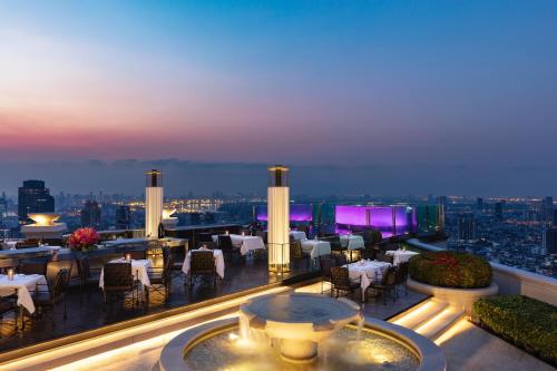 a restaurant with tables and chairs on a balcony at night at lebua at State Tower in Bangkok