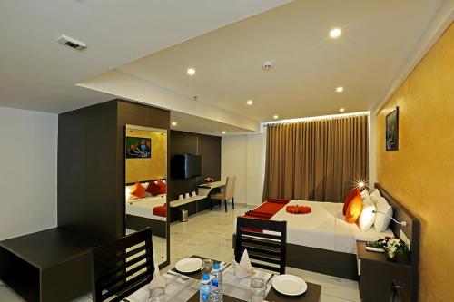 a hotel room with a bed and a dining room at Renai Sreekrishna in Guruvāyūr