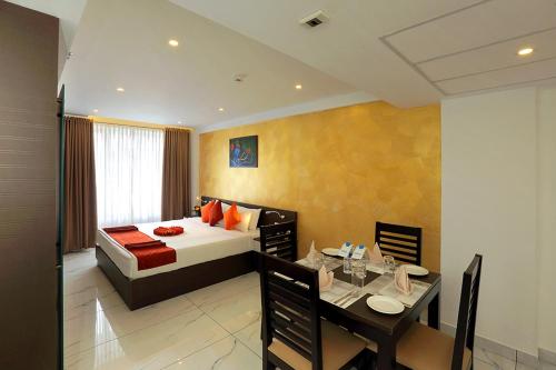 a hotel room with a bed and a dining table at Renai Sreekrishna in Guruvāyūr