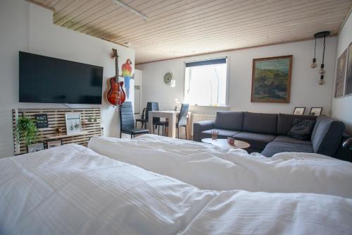 a bedroom with a bed and a couch and a flat screen tv at Studio Apartment / 20min From City Center / Tórshavn in Tórshavn
