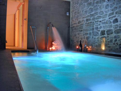 a swimming pool with a water feature and a bottle of wine at Relais Del Borgo Hotel & Spa 4 Stelle in Staffolo