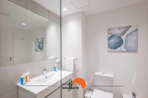 a white bathroom with a sink and a mirror at #085 Pool View, Center City with AC in Albufeira