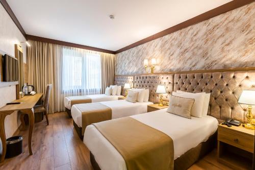 ein Hotelzimmer mit 2 Betten und einem Schreibtisch in der Unterkunft Marble Hotel in Istanbul