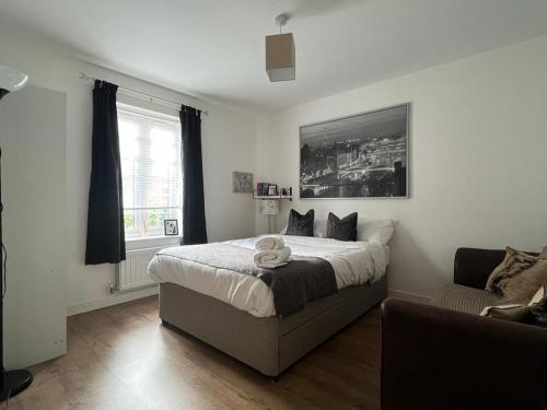 een slaapkamer met een groot bed en een bank bij Home Away from Home: Cozy Two Bedroom Apartment in Banbury