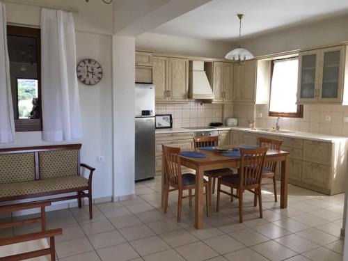 La cuisine est équipée d'une table, de chaises et d'un réfrigérateur. dans l'établissement Hotels Kalimera Inn, à Elafonisos