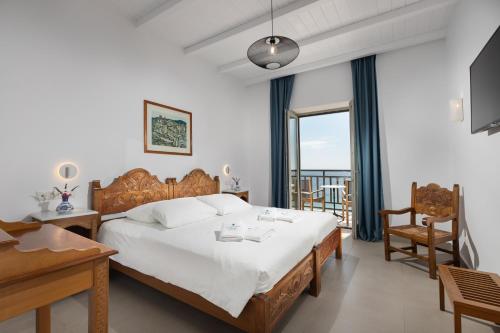 a bedroom with a large bed and a balcony at Hydroussa Skyros in Skiros