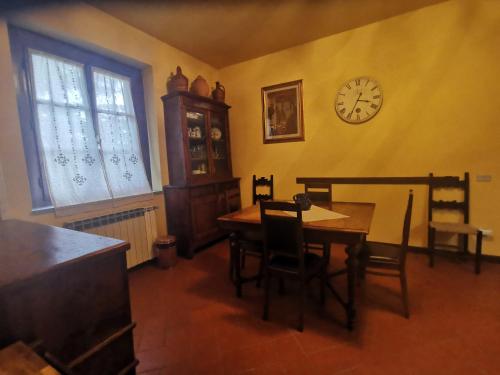uma sala de jantar com uma mesa e um relógio na parede em Villetta Il Nespolo em Barberino di Mugello