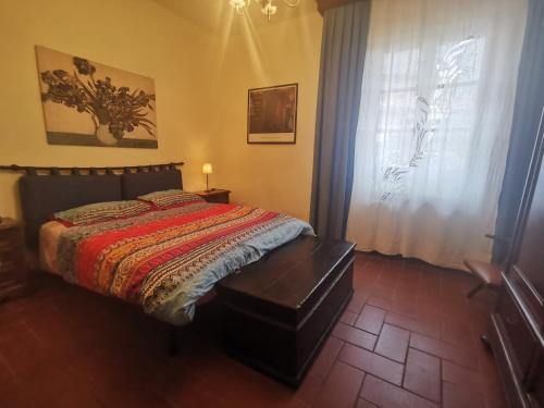 1 dormitorio con cama y ventana en Villetta Il Nespolo, en Barberino di Mugello