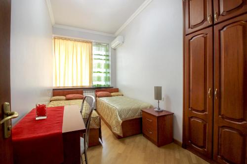 1 dormitorio con 2 camas, mesa y ventana en 2 Bedroom Apartment on Tumanyan street en Ereván