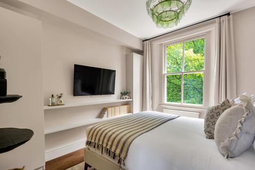 a white bedroom with a bed and a window at Be London - The St John's Wood Residences in London