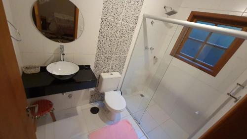 uma casa de banho com um WC, um lavatório e um espelho. em MonteVerdeMG, Fibra Óptica, fácil acesso, térrea . em Monte Verde