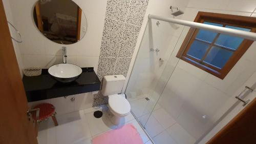 a bathroom with a toilet and a sink and a mirror at MonteVerdeMG, Vista para Montanha ,fácil acesso, térrea, Pets in Monte Verde