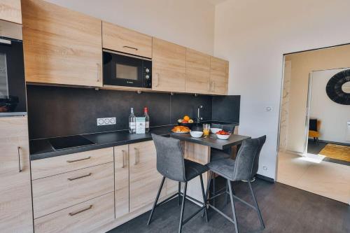 une cuisine avec une table et des chaises et un micro-ondes dans l'établissement Domaine Grand Piquecaillou - L'appartement Cadillac, à Saint-Maixant