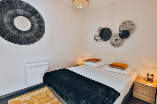 1 dormitorio con cama y espejo en la pared en Domaine Grand Piquecaillou - L'appartement Cadillac, 