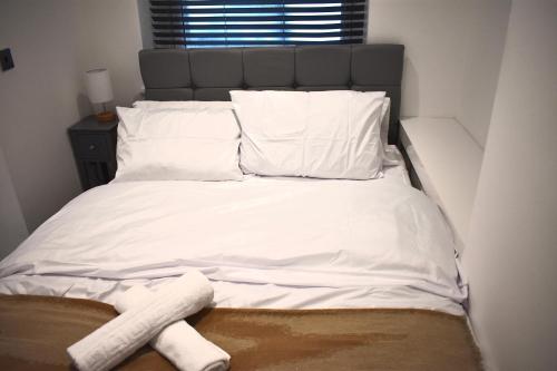 a bed with white sheets and two towels on it at The Bani Suite, a Central Brighton Luxury Apartment! in Brighton & Hove