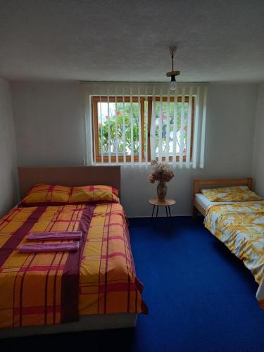 a bedroom with two beds and a window at Guest House Visoko in Visoko