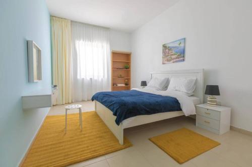 ein Schlafzimmer mit einem großen Bett mit einer blauen Decke in der Unterkunft LOVELY 3 Bedroom Apartment Beach Front (City View) in Abu Dhabi