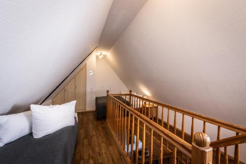 a attic room with a bed and a staircase at Gutshof Bastorf in Kühlungsborn