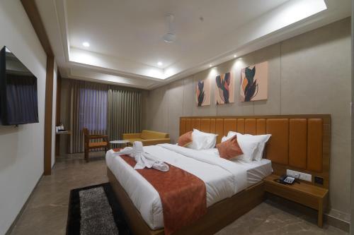 een slaapkamer met een groot bed met een teddybeer erop bij HOTEL STATURE INN in Kevadia