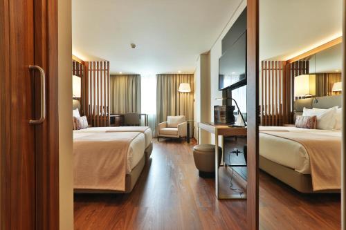 una habitación de hotel con 2 camas y una silla en TURIM Iberia Hotel en Lisboa
