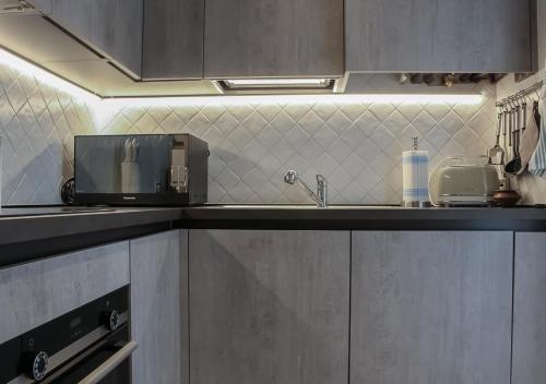 a kitchen with a sink and a microwave at ATMOSPHERE 2 CENTRALE, VISTA MARE, con parcheggio in Riccione