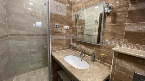a bathroom with a sink and a mirror at Seafront apartments in Bigovo