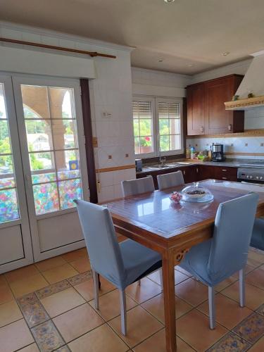 a kitchen with a wooden table and blue chairs at piso chalet en playa samil in Vigo