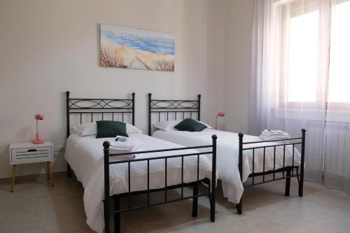 1 dormitorio con 2 camas y una foto en la pared en B&B ANNUNZIATA- Nel centro di Cosenza,vicino all' Ospedale Civile di Cosenza e alla Clinica Scarnati,con facilita' di parcheggio e servizi, en Cosenza
