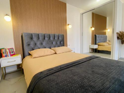 sypialnia z dużym łóżkiem z niebieskim zagłówkiem w obiekcie Baltic Avenue w Kłajpedzie