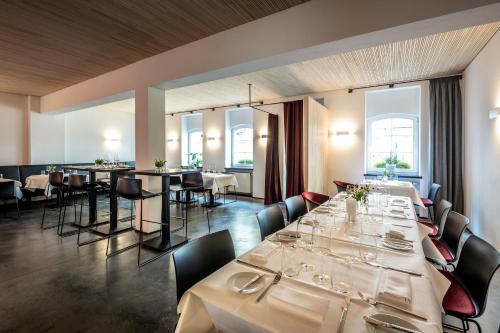 a restaurant with white tables and chairs and windows at Prümer Gang Restaurant & Hotel in Bad Neuenahr-Ahrweiler