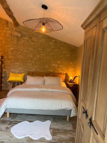 a bedroom with a bed and a stone wall at La chambre l'Eucalyptus in Saint-Laurent-du-Bois