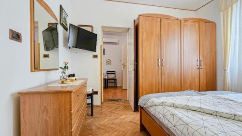 Schlafzimmer mit einem Bett und einer Kommode mit einem TV in der Unterkunft Apartment Alba in Brtonigla