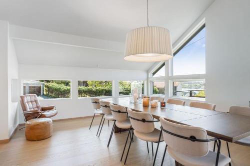 a dining room with a long table and chairs at Exclusive Family Villa in Haugesund - Lovely Ocean View, 5 Bedroom, Free parking in Haugesund