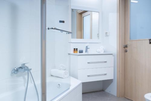 a white bathroom with a sink and a mirror at O&O Group - SeaFront Luxurious 3 BR Apartment in Bat Yam