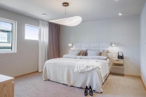 a white bedroom with a large bed and a window at Exclusive Family Villa in Haugesund - Lovely Ocean View, 5 Bedroom, Free parking in Haugesund