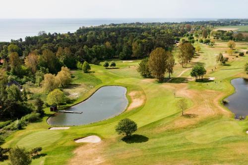 an overhead view of a golf course with a pond at Bedinge Golfklubb hotell in Beddinge Strand