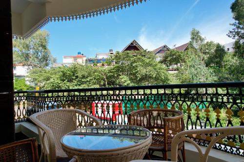 d'un balcon avec une table, des chaises et une clôture. dans l'établissement Forest View Resort, à Yercaud