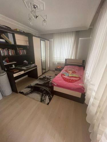um quarto com uma cama vermelha e uma secretária em Cadde Üstü, Deniz Manzaralı Ferah bir daire em Gemlik