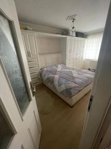 um pequeno quarto com uma cama e uma porta em Cadde Üstü, Deniz Manzaralı Ferah bir daire em Gemlik